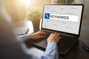 A business owner on his desktop computer typing in the word 'keywords' to a search engine