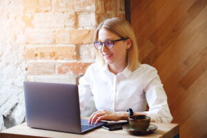 Picture of a blonde haired female SEO consultant having a zoom meeting on her laptop with a client